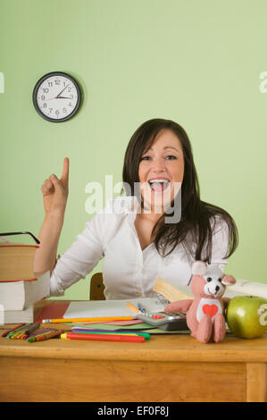 Teacher sitting at desk Banque D'Images