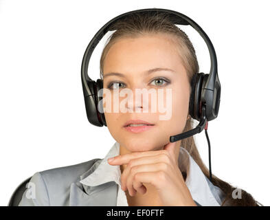 Businesswoman in headset sitting on chair, la main sous le menton Banque D'Images