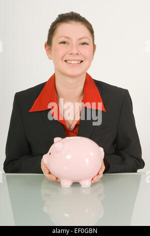 Businesswoman holding a piggy bank Banque D'Images