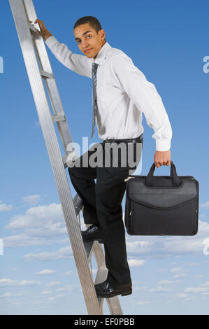 Businessman climbing ladder dans le ciel Banque D'Images