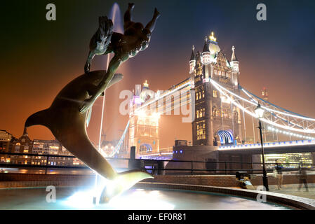 Le Tower Bridge et la statue d'une jeune fille jouant avec dauphin en St Katharine Docks de Londres. Banque D'Images