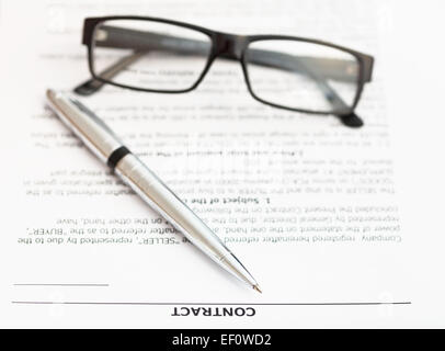 Plume d'argent et les lunettes sur les pages de contrat de vente Banque D'Images