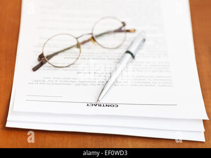 Pages de contrat de vente et de l'argent et les lunettes stylo sur table en bois Banque D'Images