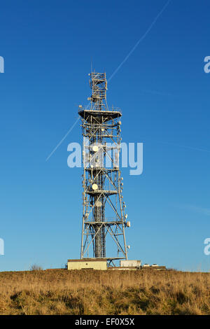 La tour de télécommunications. Full ladened mât radio contre un ciel bleu. Traînée passant derrière. Banque D'Images