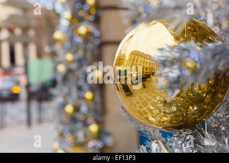 Boule de Noël brillante d'or sur la rue décorée à Paris, France Banque D'Images