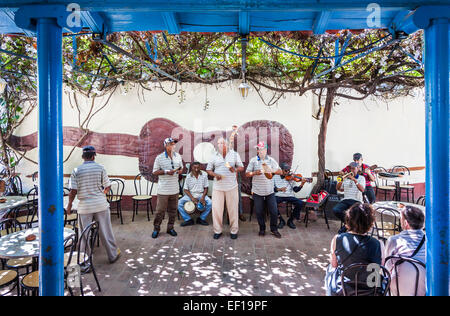 Sept cubains typiques de musiciens jouant dans un restaurant l'exécution de musique et chant pour le divertissement des touristes à Trinidad, Cuba Banque D'Images