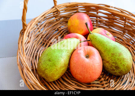 La vie toujours composé de fruits et pommes placées dans un des paniers en osier, éclairé par la lumière naturelle Banque D'Images