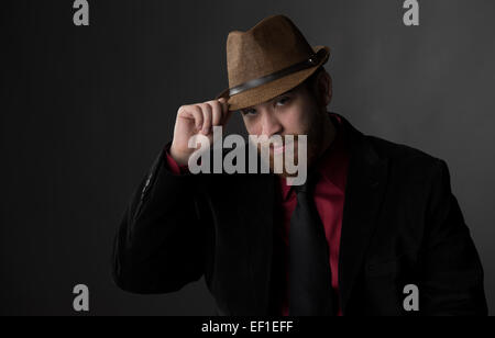 Homme splendide dans l'usure formelle tenant son chapeau brun Banque D'Images