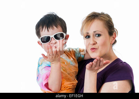 Pretty young woman holding a trois ans boy blowing kisses. Banque D'Images