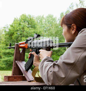 Jeune femme tournage un fusil automatique pour strikeball Banque D'Images