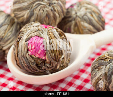 Le thé vert avec des boules de fleurs en cuillère en bois sur la table de cuisine Banque D'Images