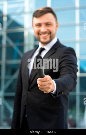 L'occasion ou Toastmaster posant avec microphone sur le fond contempopary Banque D'Images