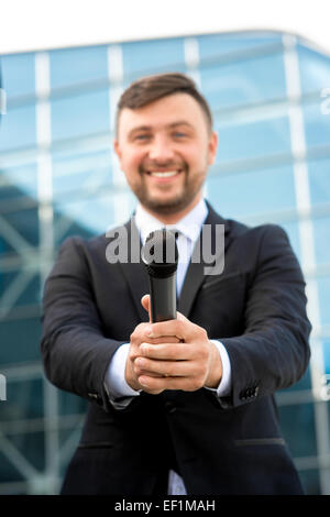 L'occasion ou Toastmaster posant avec microphone sur le fond contempopary Banque D'Images