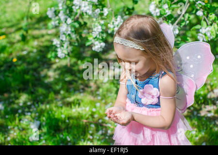 Petite fille avec une coccinelle dans les mains à la floraison de apple orchard Banque D'Images