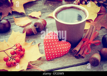 Réchauffement de la tasse à café, coeur rouge et à l'automne sur la vie toujours vieille table Banque D'Images