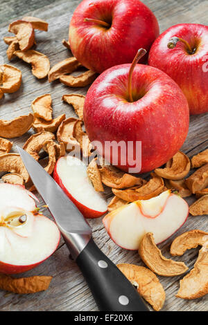 Des tranches de pommes séchées et rouge pommes fraîches sur la table de cuisine Banque D'Images