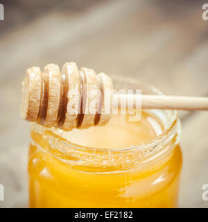 Le miel en pot de verre et du balancier à close up Banque D'Images