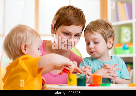 Femme et enfants jouant avec des peintures Banque D'Images