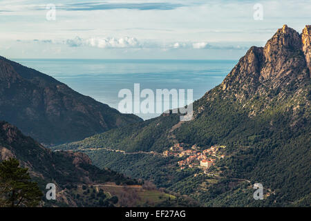 Le village d'Ota en Corse avec les montagnes et la mer Méditerranée derrière Banque D'Images