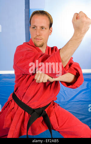 Un homme dans une salle de sport faire karate Banque D'Images