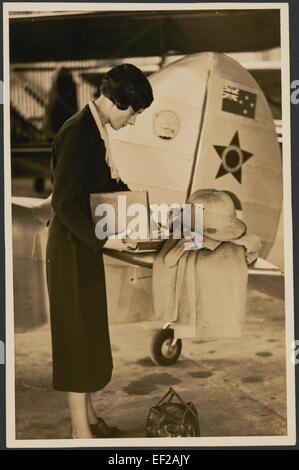 Ce portrait de l’aviateur Jean Batten, pris près de la queue de son avion, capture un moment de sa carrière pionnière dans l’aviation. Batten est connue pour ses vols record dans les années 1930 Banque D'Images
