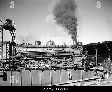 La locomotive 715 se trouve sur une plaque tournante à la tour du Texas & Pacific Railway, présentant les activités de maintenance et d'exploitation dans les ateliers de chemin de fer. Cette image reflète le rôle crucial des rondes et des plateaux tournants dans la gestion des locomotives dans les gares de triage pour le service et le stockage. Banque D'Images