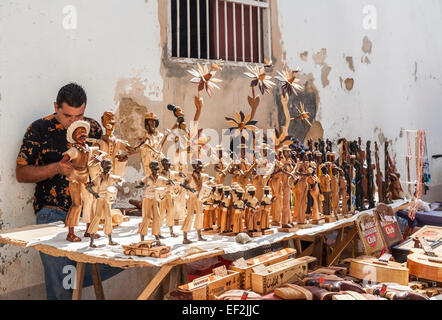 Vie locale cubaine : mâle locale exposant avec des statues en bois de personnes à vendre comme souvenirs touristiques à un décrochage dans le centre-ville de Trinidad, Cuba Banque D'Images