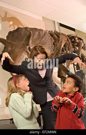 L'enseignant et les étudiants en musée par le fossile de dinosaure afficher Banque D'Images