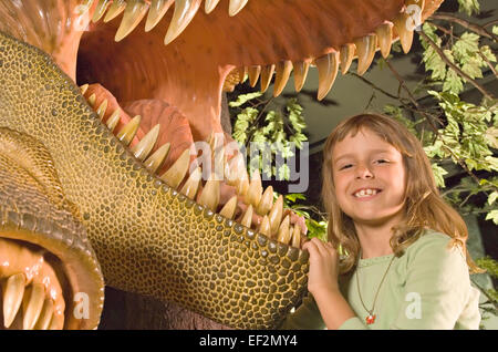 Jeune étudiant en jouant par musée diorama de dinosaures Banque D'Images