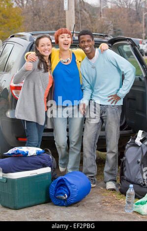 Trois amis l'emballage pour un voyage de camping Banque D'Images