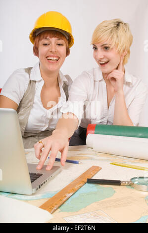 Deux femmes heureux looking at laptop Banque D'Images