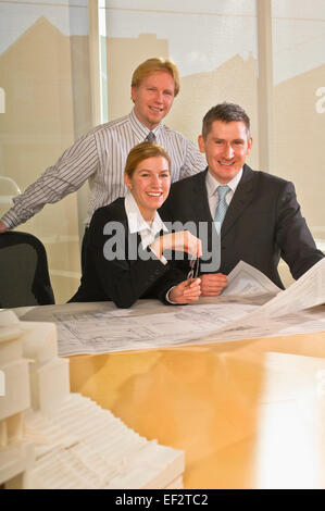 Architects looking at blueprints Banque D'Images