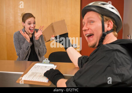 Location courier donnant fort à excité réceptionniste de bureau Banque D'Images