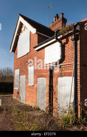 Maison individuelle dans un jardin luxuriant avec des feuilles de sécurité métalliques fermés pour éviter d'endommager les squatters entrée illégale de propriété Banque D'Images