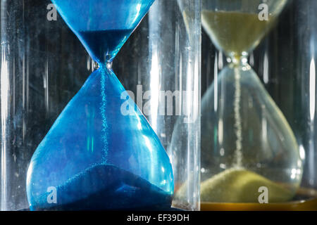 Hourglass minuterie streaming grains de sable s'écoulant à travers illustrant les choses s'épuisent Banque D'Images