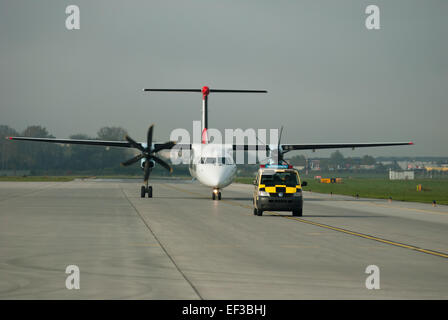 L'avion OE-LGJ, un Bombardier Dash 8 Q400, atterrit en toute sécurité à l'aéroport d'Innsbruck (Flughafen Innsbruck) en Autriche. Cet avion régional est largement utilisé pour les vols court-courriers, connu pour son efficacité et sa capacité à opérer en terrain montagneux. Banque D'Images