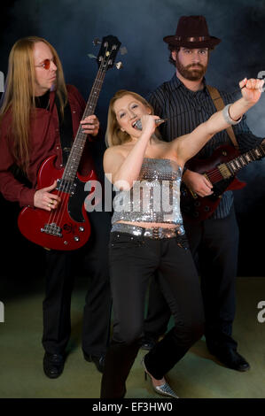 Femme chantant avec deux joueurs de guitare Banque D'Images