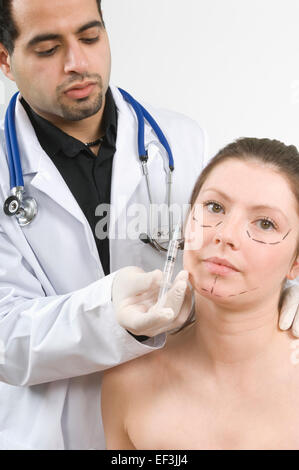 Doctor giving patient une aiguille sur son visage Banque D'Images