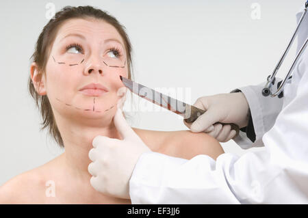 Doctor holding un couteau sanglant en face de woman's face Banque D'Images