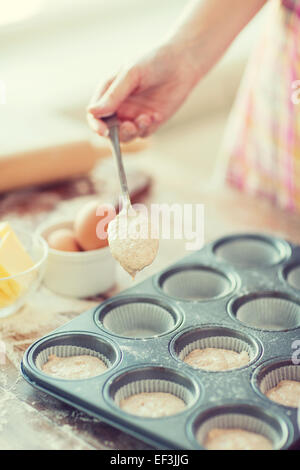 Remplissage de moules muffins avec la pâte Banque D'Images