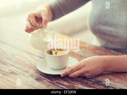 Portrait de femme versant du lait dans le café Banque D'Images