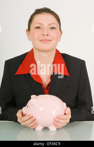 Businesswoman holding a piggy bank Banque D'Images