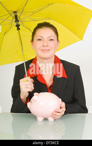 Businesswoman holding a piggy bank et ombrelle Banque D'Images