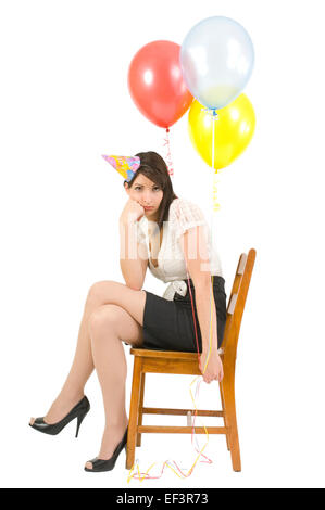 Woman wearing party hat and holding balloons Banque D'Images