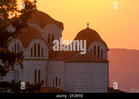 Eglise d'Agia Marina avec le soleil derrière d'une couleur orange dans le ciel. Athènes, Grèce Banque D'Images