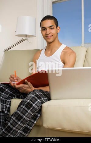 Man sitting on couch with laptop Banque D'Images