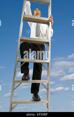 Businessman climbing ladder dans le ciel Banque D'Images