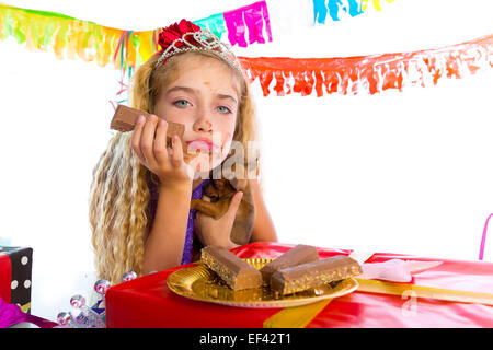 Geste ennuyé kid girl blonde en partie avec des chocolats et chiot chihuahua dog Banque D'Images