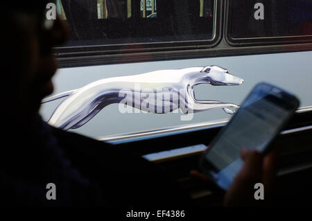 Un passager d'autobus Greyhound utilise un smartphone à bord. Banque D'Images