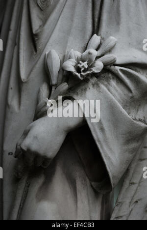 Détails de la main d'un ange avec des fleurs, faisant partie d'une figure d'ange pleureuse au musée Taman Prasati (musée du parc en pierre commémoratif) à Jakarta, Indonésie. Banque D'Images